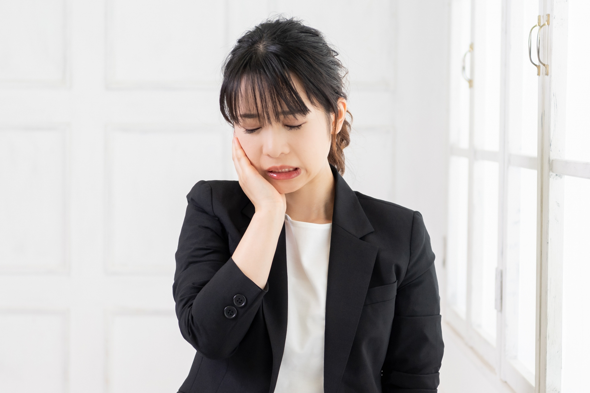 顎の痛みを気にする女性